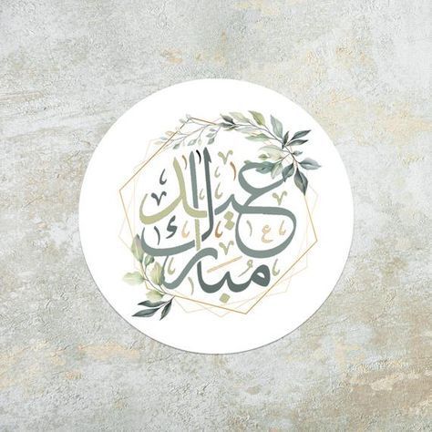 ملصق دائري أنيق بخط عربي لعبارة "عيد مبارك" مع زخارف نباتية خضراء.